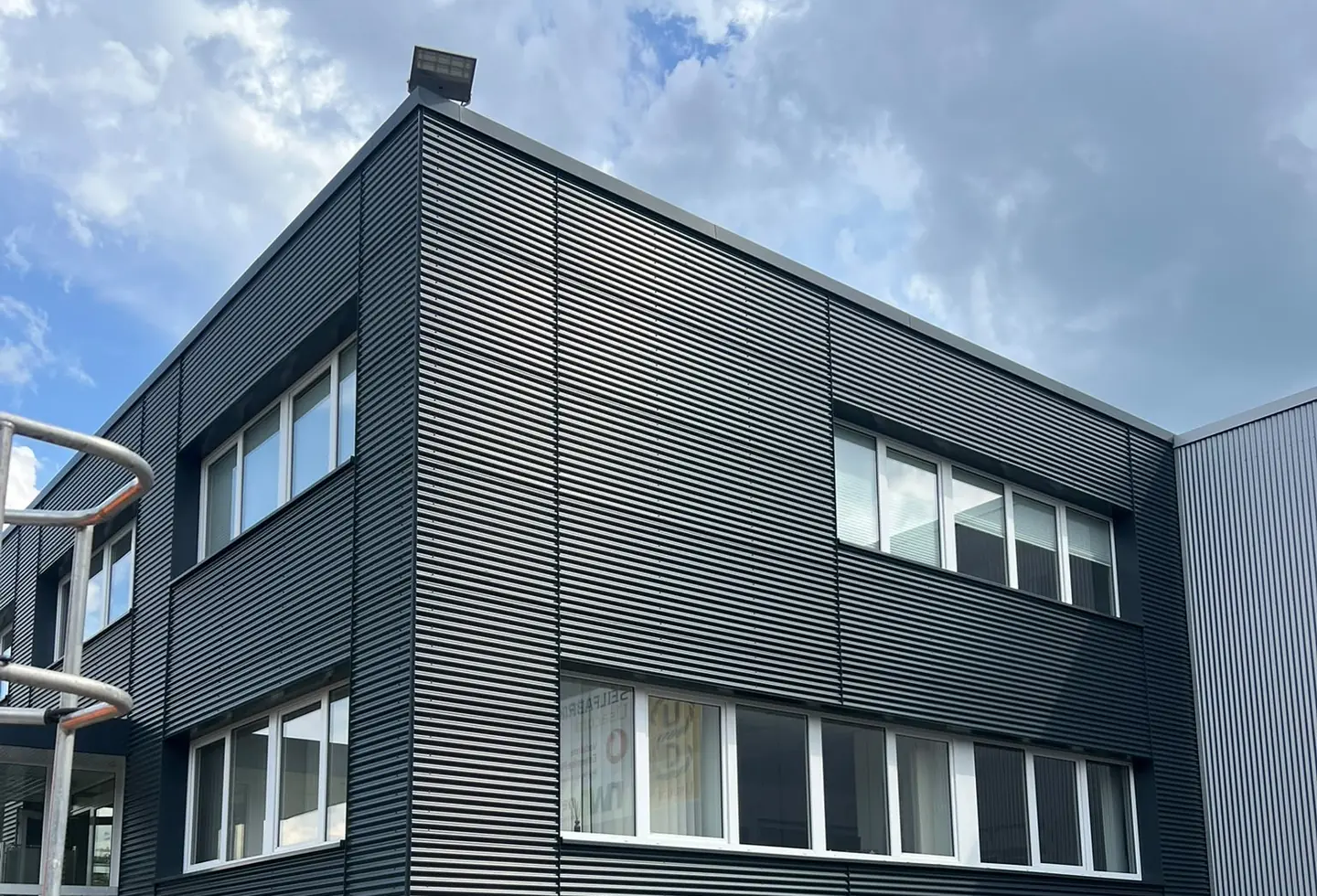 Geplante Reinigung einer hohen Gewerbefassade mit sicherem Zugangssystem