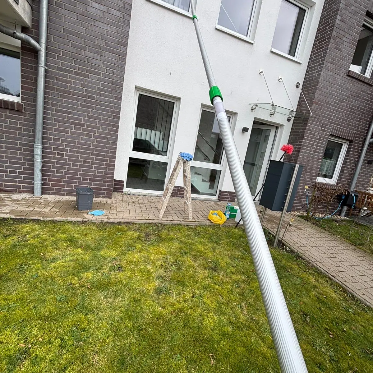 Fassadenreinigung – Mehrwert für Unternehmen und Praxen 4 Fassadenreinigung an einem mehrgeschossigen Gebäude mit wasserführender Teleskopstange