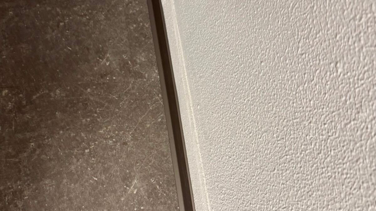 Verschmutzte Randzone eines Bodenbelags an einer Wand