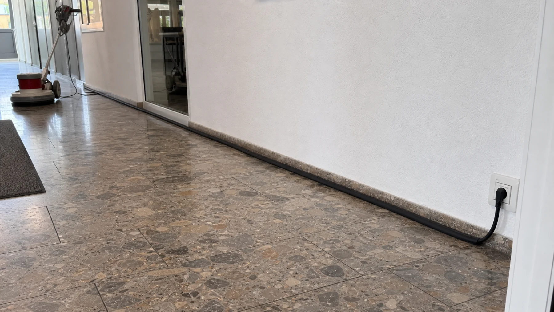 Kabel und Schläuche bei der Reinigung: Der Flur bleibt frei 1 Sicher geführtes Maschinenkabel neben einem freien Verkehrsweg bei der Bodenreinigung